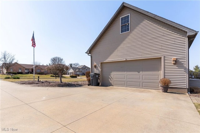 view of property exterior featuring concrete driveway and a garage