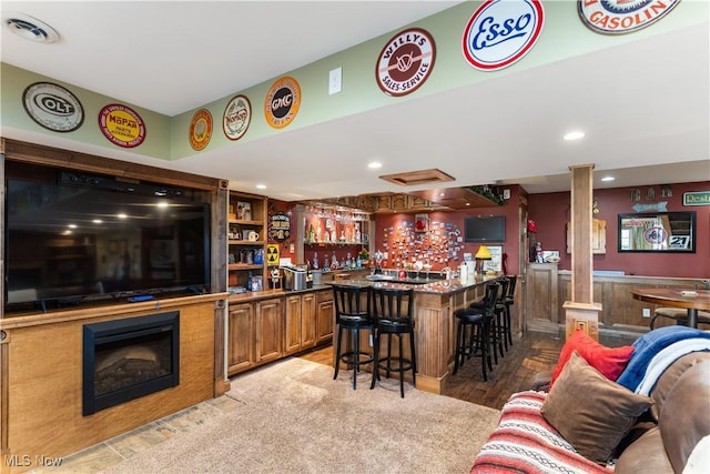 bar featuring visible vents, ornate columns, a fireplace, recessed lighting, and bar