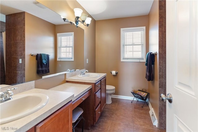 full bathroom with a sink, toilet, double vanity, and tile patterned flooring