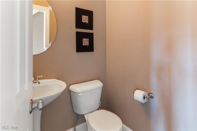 half bath with toilet and baseboards