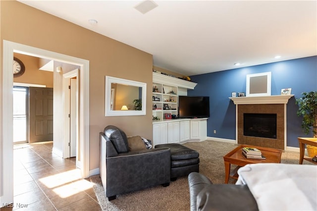 carpeted living area with tile patterned flooring, a fireplace, and baseboards