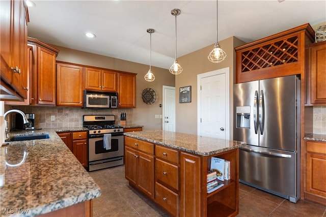 kitchen with tasteful backsplash, a center island, appliances with stainless steel finishes, brown cabinetry, and a sink