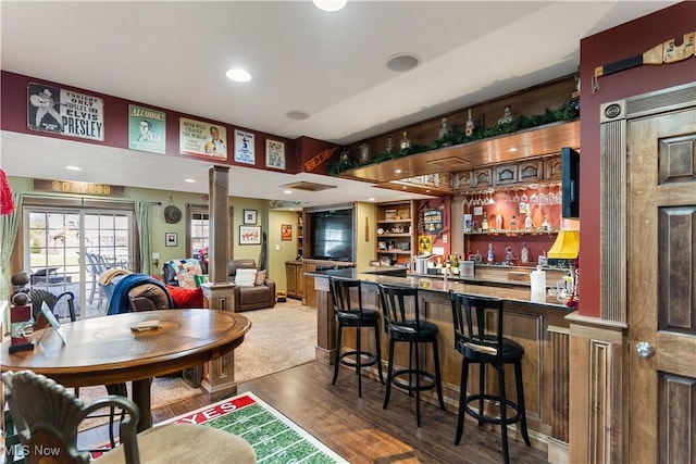 bar with recessed lighting, bar, wood finished floors, and ornate columns