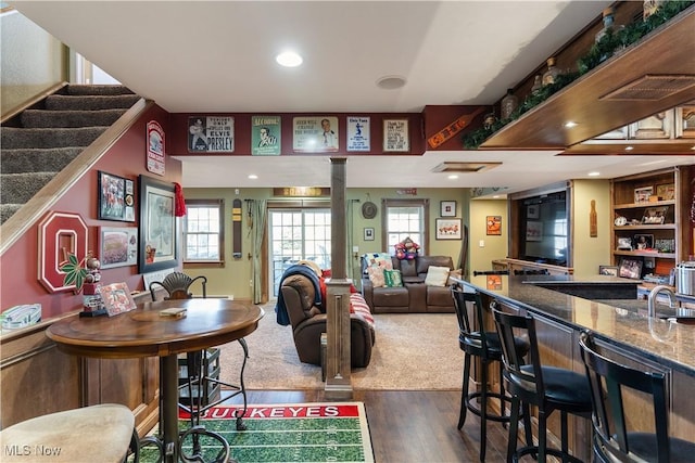 interior space featuring visible vents, bar area, stairs, recessed lighting, and dark wood-style floors