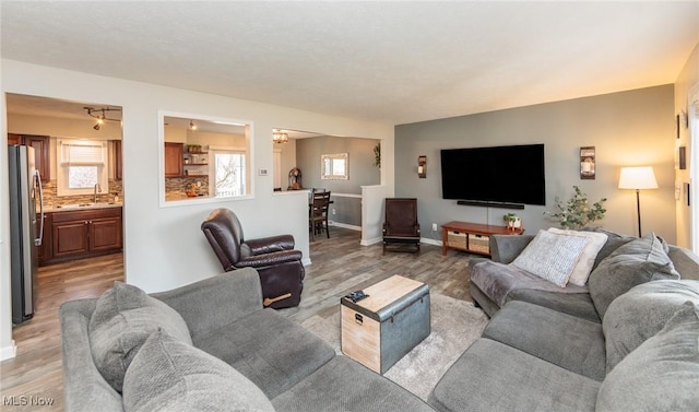 living area featuring baseboards and light wood-type flooring