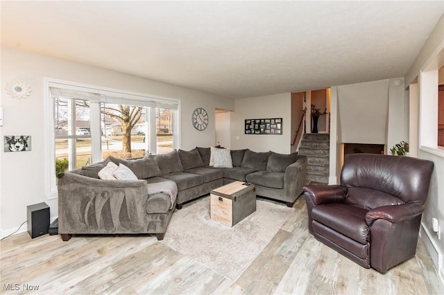 living room featuring stairs and light wood finished floors