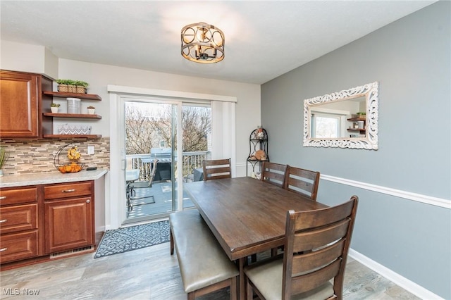 dining room with light wood-type flooring and baseboards