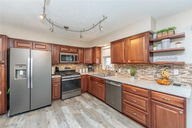 kitchen with light wood finished floors, a sink, brown cabinetry, stainless steel appliances, and open shelves