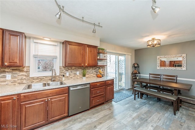 kitchen featuring a sink, backsplash, stainless steel dishwasher, and brown cabinetry