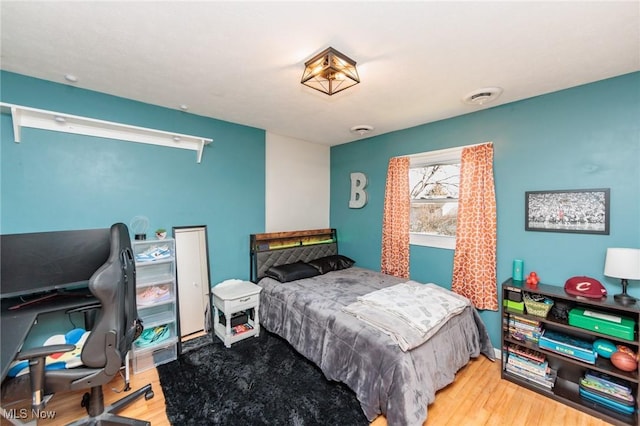 bedroom with visible vents and wood finished floors