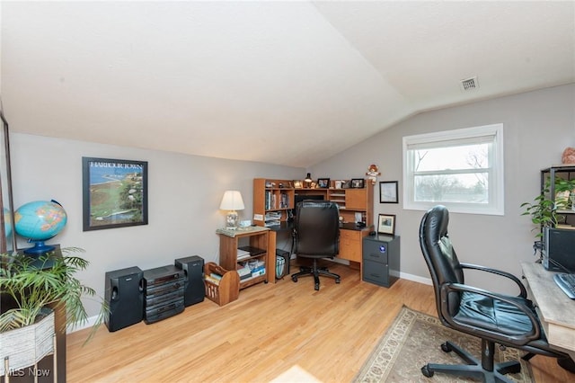 office area with vaulted ceiling, visible vents, baseboards, and light wood finished floors