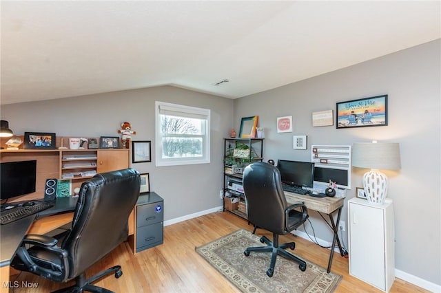 office with baseboards, wood finished floors, and vaulted ceiling