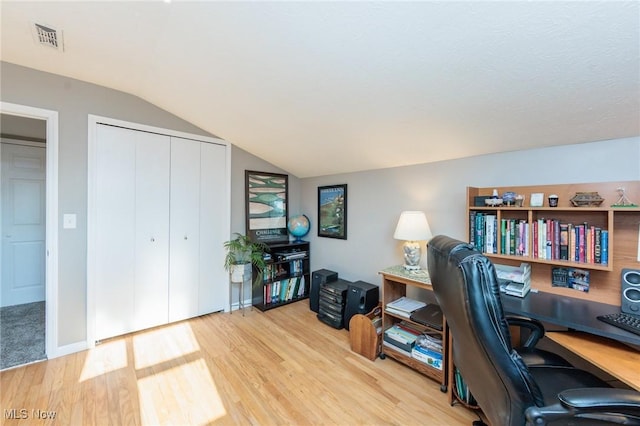 office area featuring visible vents, lofted ceiling, and wood finished floors