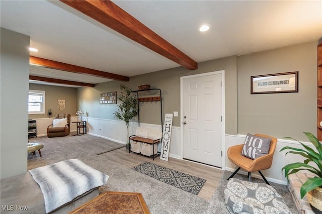 living area featuring recessed lighting, baseboards, beam ceiling, and wood finished floors