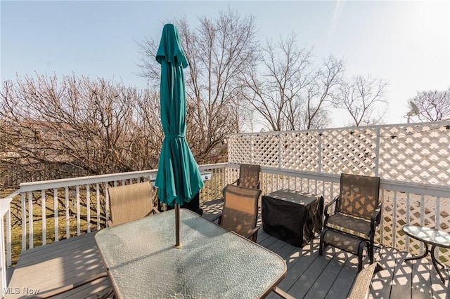 deck with outdoor dining area and a grill