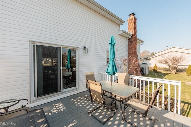 wooden deck featuring outdoor dining space and a yard