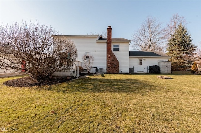 rear view of property with a yard and a chimney