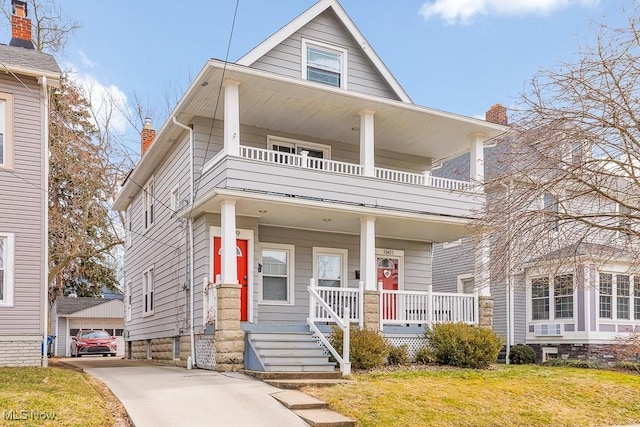 view of front of home with a porch, a balcony, and a front lawn