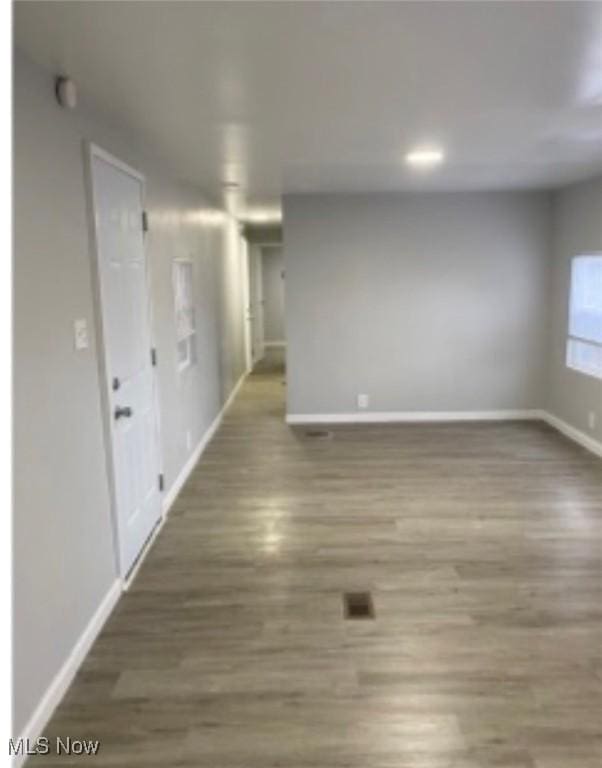 spare room featuring baseboards and wood finished floors