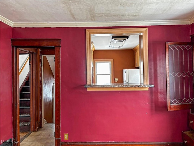 corridor featuring a textured ceiling, ornamental molding, and stairs