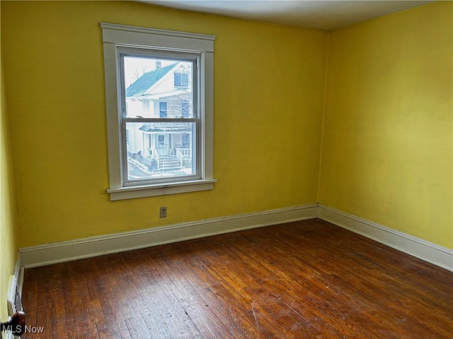 spare room with hardwood / wood-style flooring and baseboards