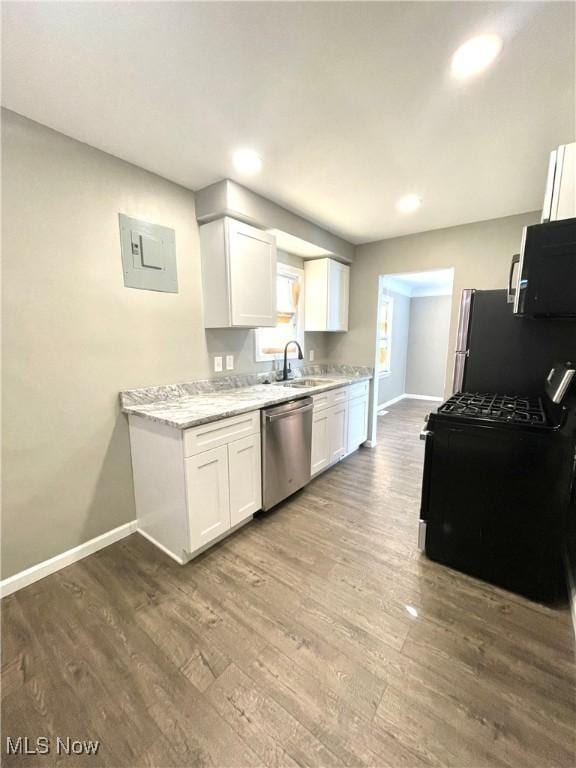 kitchen with white cabinetry, wood finished floors, baseboards, and stainless steel appliances