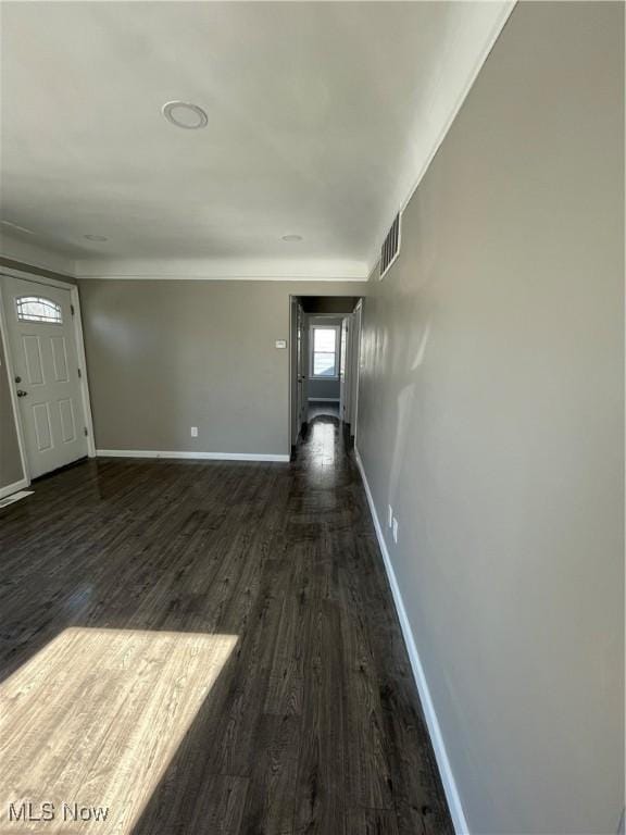 interior space with visible vents, baseboards, and dark wood-style floors