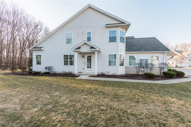 view of front of property with a front yard and roof with shingles