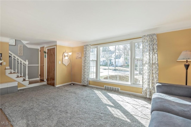 unfurnished living room featuring stairway, carpet flooring, baseboards, and visible vents