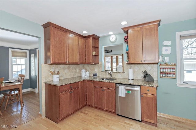 kitchen featuring open shelves, light stone counters, stainless steel dishwasher, and a healthy amount of sunlight