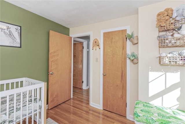 bedroom with light wood-style flooring and baseboards