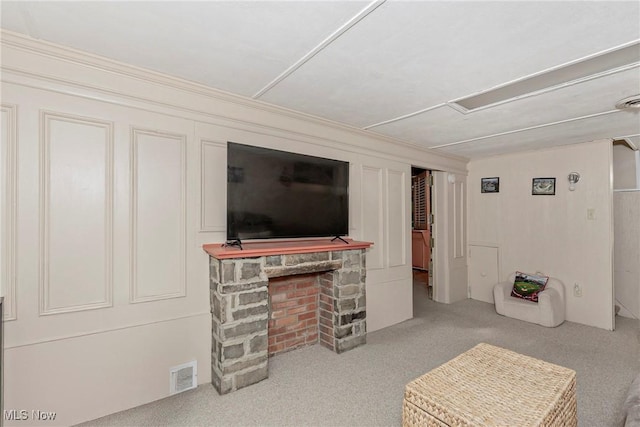 carpeted living area with a stone fireplace and visible vents