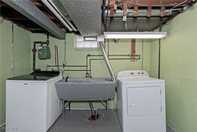 laundry area with laundry area, separate washer and dryer, and a sink