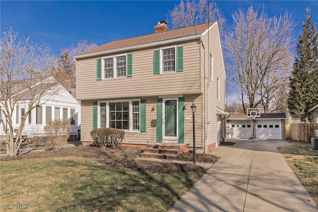 colonial home featuring an outbuilding, a front yard, central AC unit, a chimney, and a garage