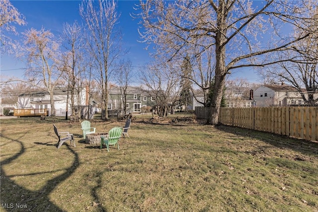 view of yard with a residential view, an outdoor fire pit, and fence