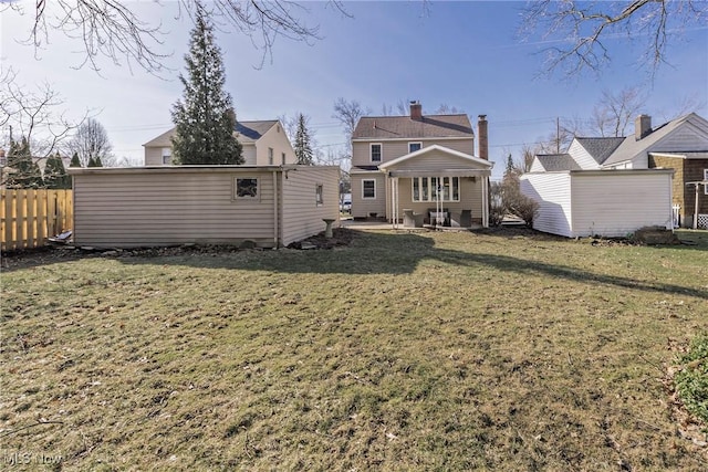 rear view of house featuring a yard, a patio area, an outdoor structure, and fence