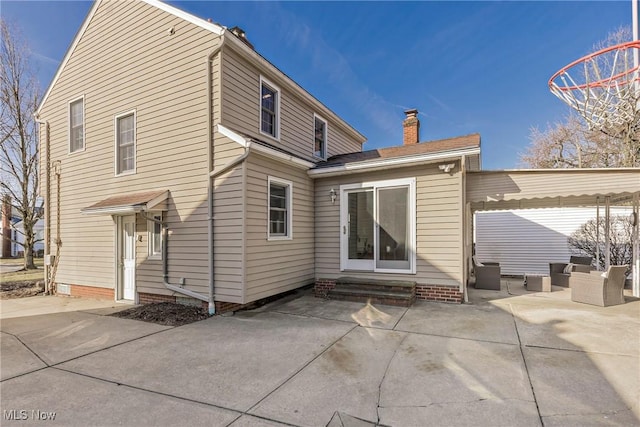 rear view of house with an outdoor living space, a patio area, a chimney, and entry steps