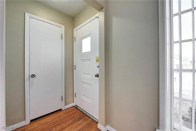 foyer entrance with light wood finished floors and baseboards