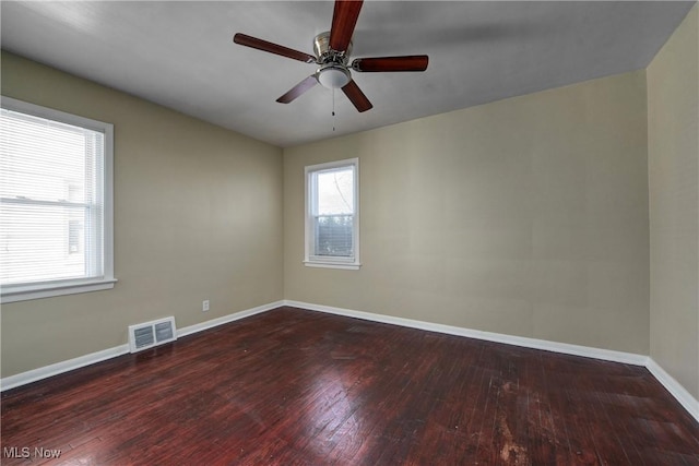 empty room with visible vents, baseboards, ceiling fan, and hardwood / wood-style flooring