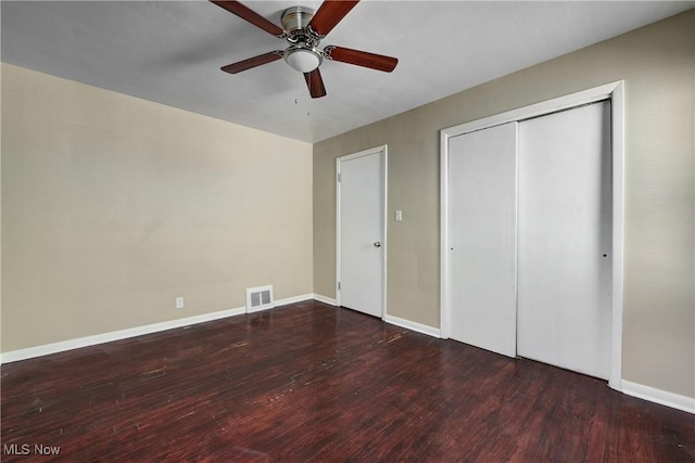 unfurnished bedroom featuring wood finished floors, visible vents, a closet, and baseboards