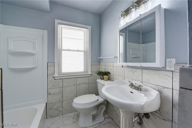 full bathroom with tile walls, toilet, and marble finish floor