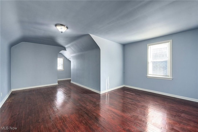 bonus room with baseboards, lofted ceiling, and hardwood / wood-style flooring