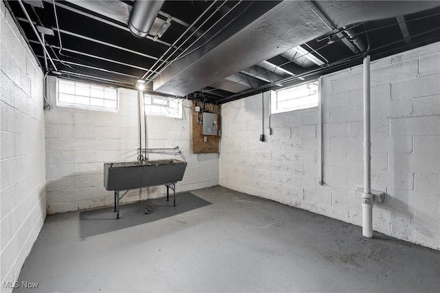 basement with electric panel and a sink