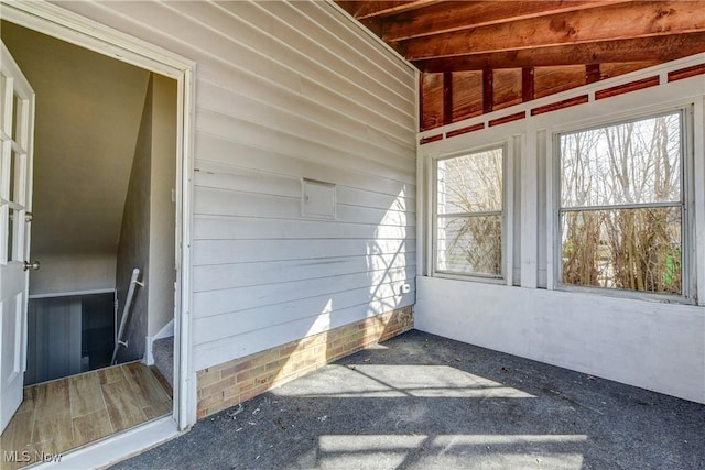 unfurnished sunroom featuring vaulted ceiling and a wealth of natural light