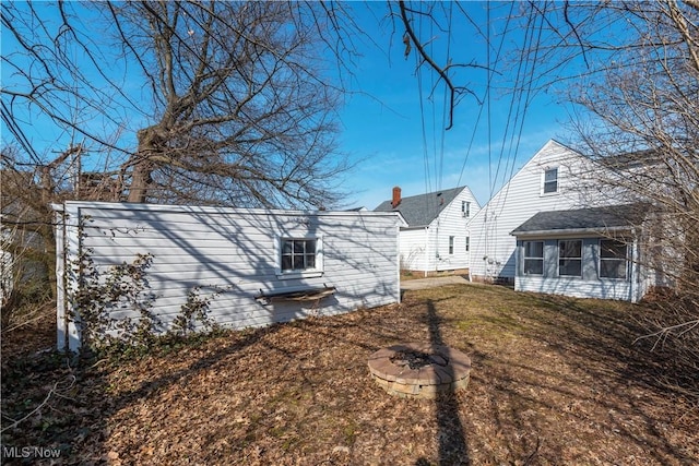 view of side of home with a yard and an outdoor fire pit