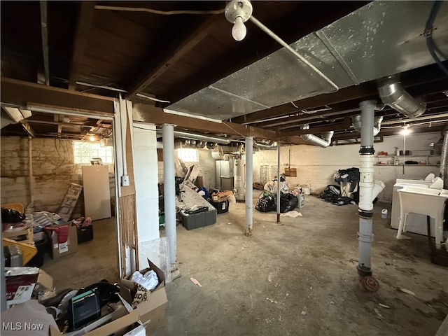 basement with refrigerator and a sink