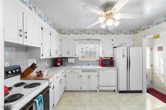 kitchen with a sink, white appliances, white cabinets, light countertops, and decorative backsplash