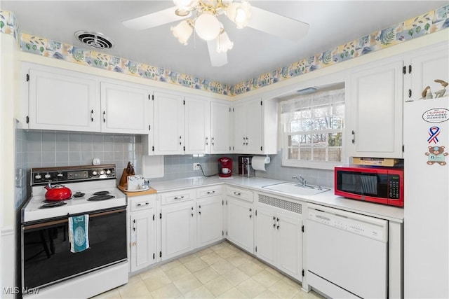 kitchen featuring white appliances, white cabinetry, light countertops, and a sink