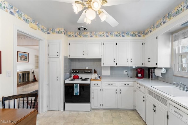 kitchen with visible vents, a sink, white cabinetry, white appliances, and light countertops