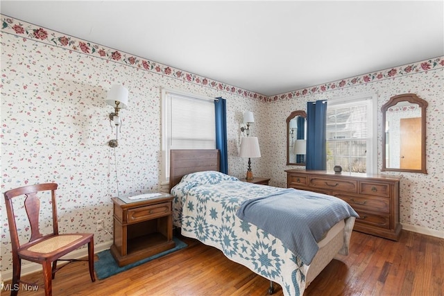 bedroom featuring wallpapered walls, baseboards, and hardwood / wood-style flooring